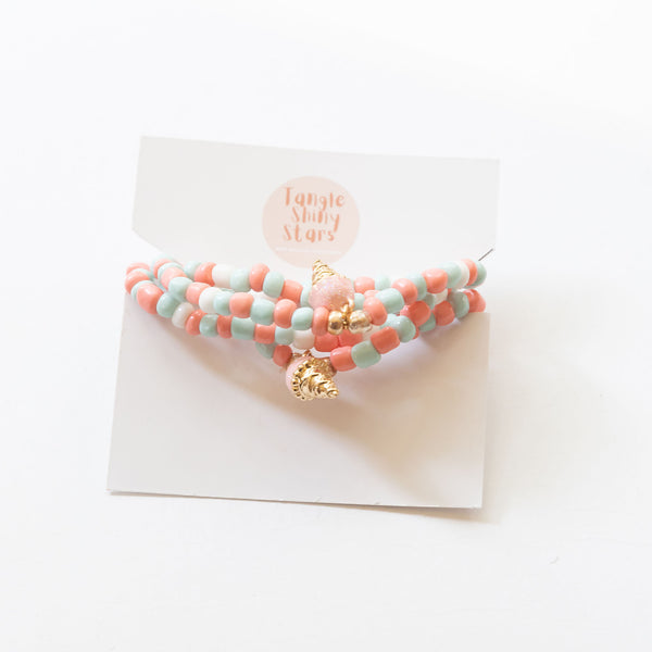 a set of bracelet and necklace with ice cream charms on the tag