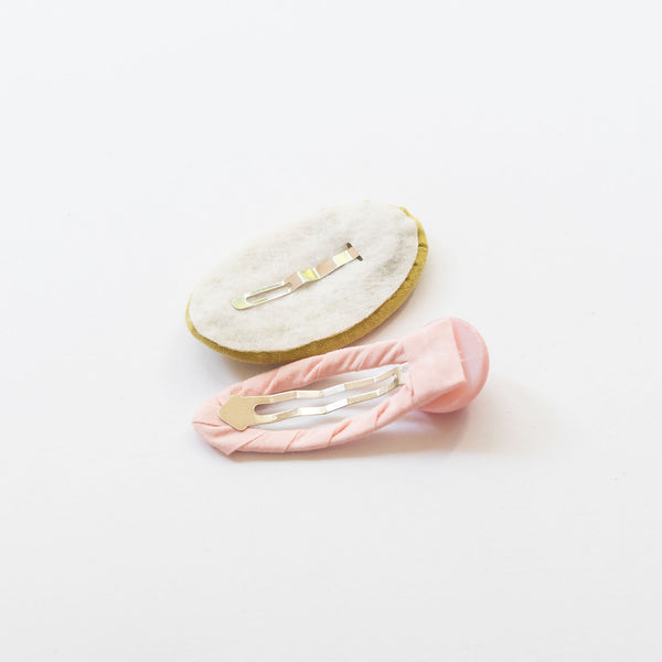 back side of light pink oval embroidered hair clips