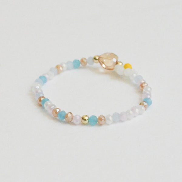 a bracelet with a heart charm and made of glass beads