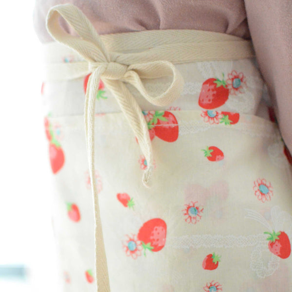 a half apron with strawberry prints