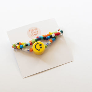 multi colored beaded necklace with smiley charm with a tag