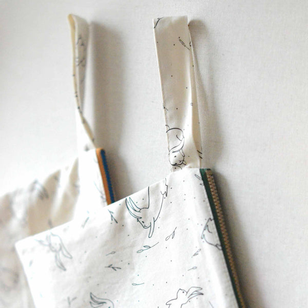 hold strings of the cotton pouch with rabbit prints hanging on the wall